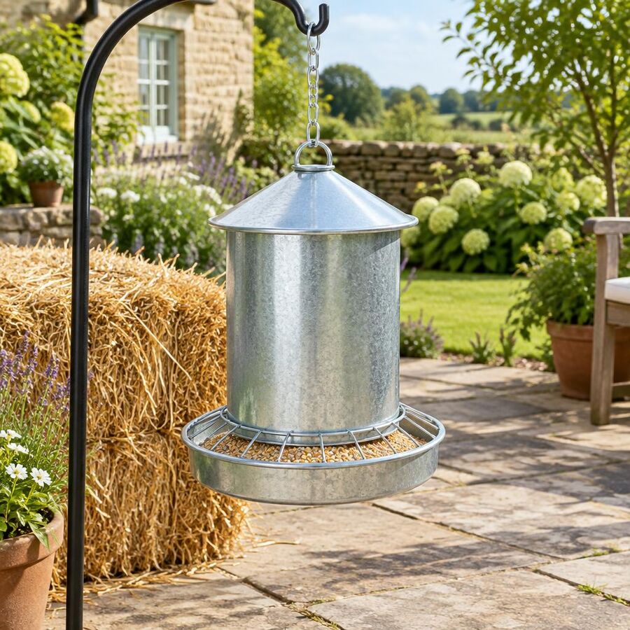 Galvanised steel hanging poultry feeder in an English garden